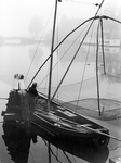 361028 Afbeelding van visser P. Arbeider met zijn vissersboot in het Merwedekanaal te Utrecht, met op de achtergrond de ...